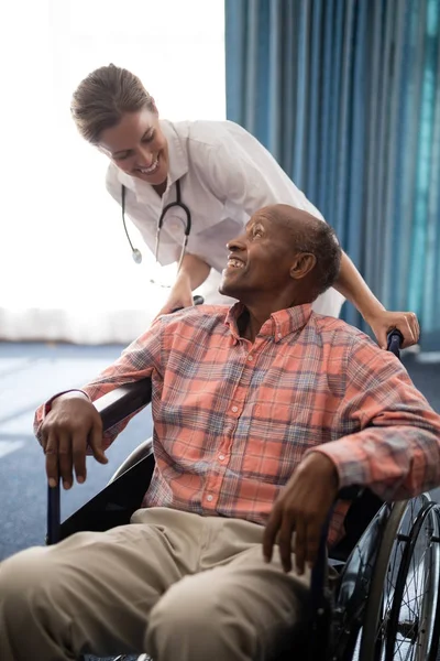 Lekarz ogląda niepełnosprawny starszy mężczyzna — Zdjęcie stockowe
