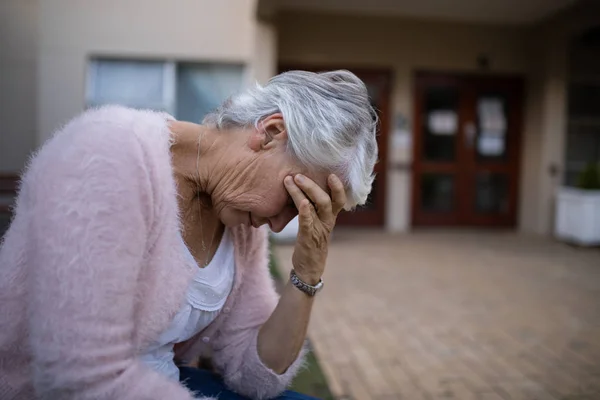 Deprimida mujer mayor sentada en el banco — Foto de Stock