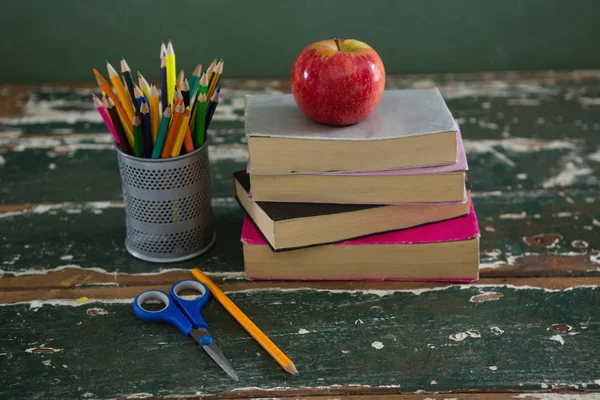 Apfel auf Stapel Bücher mit verschiedenen Papeterie — Stockfoto