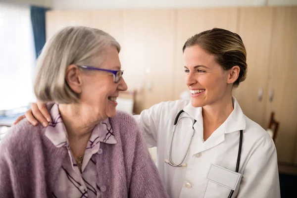 Kvinnliga läkare tittar på äldre kvinna — Stockfoto