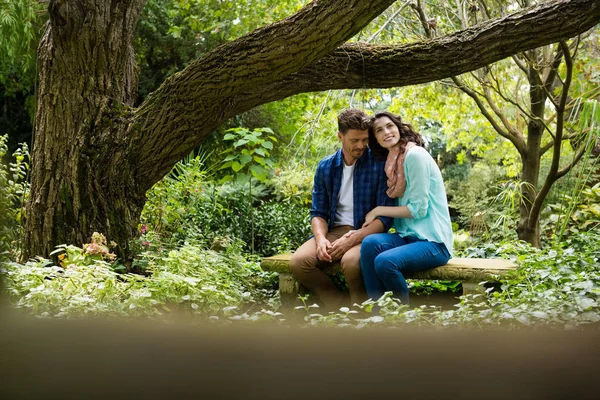 Романтична пара сидить на лавці в саду — стокове фото