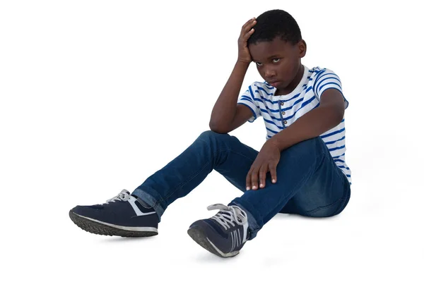 Sad boy sitting with hand on head — Stock Photo, Image