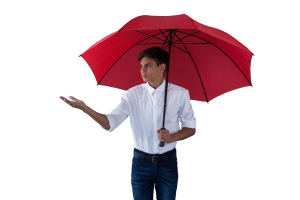 Boy standing under a red umbrella — Stock Photo, Image