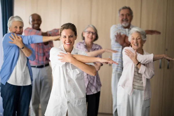 Kvinnliga läkare och seniorer stretching arm — Stockfoto