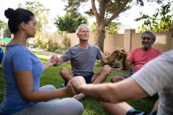 Entrenador meditando con personas mayores —  Fotos de Stock