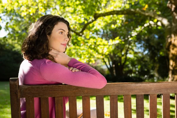 Frau sitzt auf Bank im Garten — Stockfoto