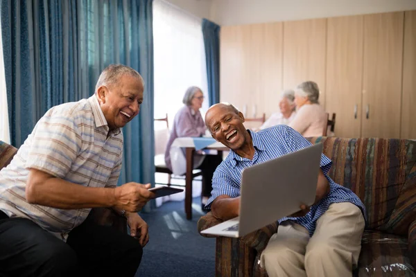 Felices amigos mayores mirando el portátil — Foto de Stock