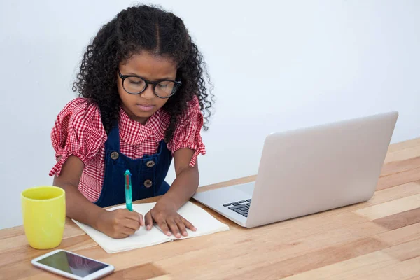 Zakenvrouw schrijven op boek door laptop — Stockfoto