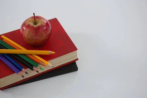 Manzana y lápiz de color en el libro —  Fotos de Stock