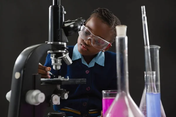 Colegiala usando microscopio — Foto de Stock