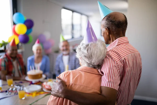 Pareja de ancianos mirando a los amigos durante la fiesta —  Fotos de Stock