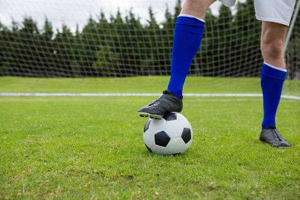 Jogador de futebol com bola em campo — Fotografia de Stock