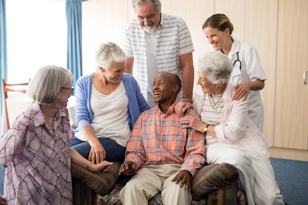 Vänner och läkare tittar på glada senior mannen — Stockfoto