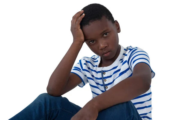 Smutny chłopiec siedzi z ręki na głowie — Zdjęcie stockowe