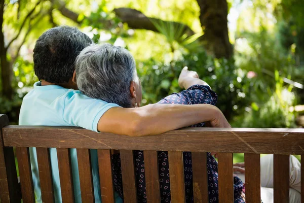 Seniorenpaar zeigt auf Abstand im Garten — Stockfoto