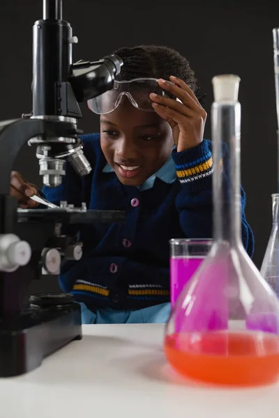 Écolière utilisant un microscope — Photo