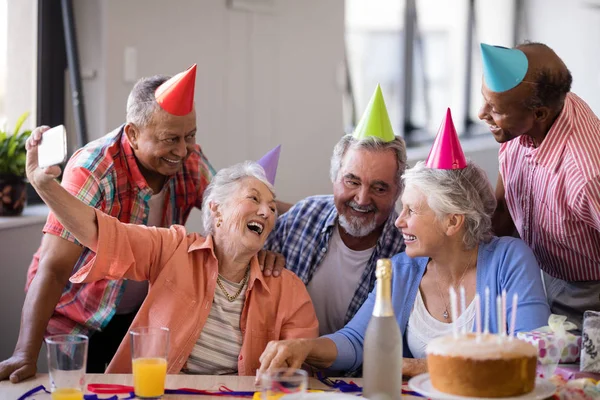 Femme âgée prenant selfie avec des amis à la fête — Photo