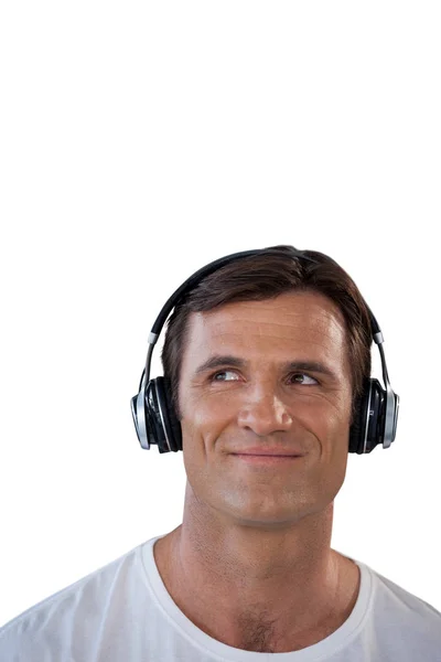 Усміхнений зрілий чоловік у навушниках дивиться геть — стокове фото