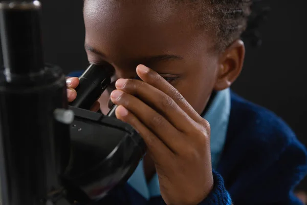 Colegiala usando microscopio — Foto de Stock