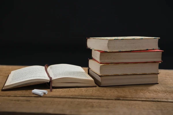 Books and chalk on table — Stock Photo, Image