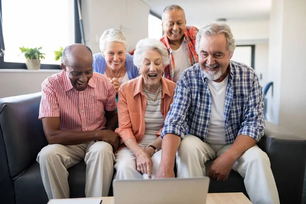 Senior vrienden kijken naar laptop op tafel — Stockfoto