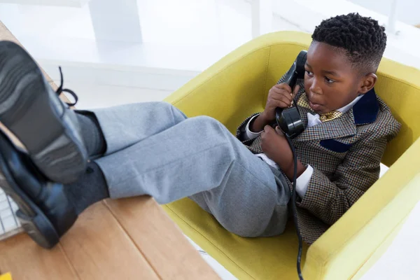 Vista de ángulo alto del niño imitando como hombre de negocios hablando por teléfono fijo — Foto de Stock