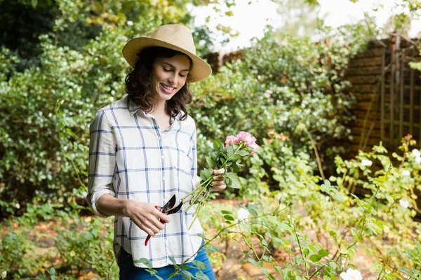 Woman trimming flowers with pruning shears — Stock Photo, Image