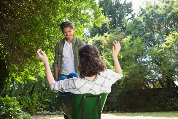 Man interagerar med kvinna samtidigt som du trycker skottkärra — Stockfoto