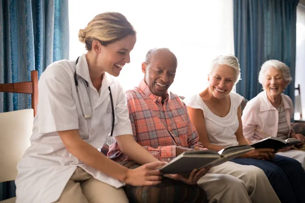 Vrouwelijke arts leesboek voor senior mensen — Stockfoto