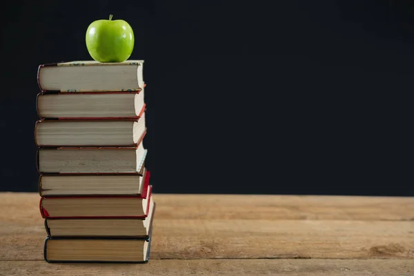 Manzana verde en pila de libros —  Fotos de Stock