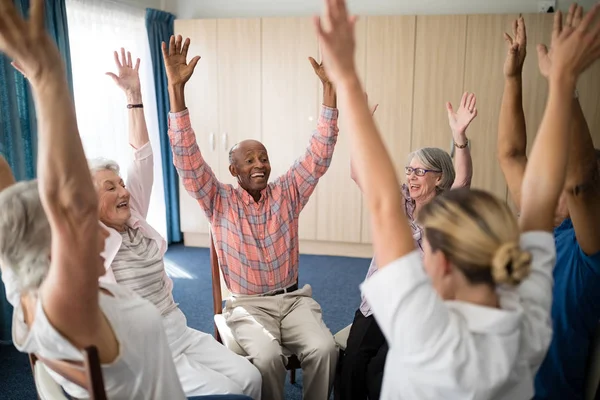 Anziani e medico femminile con le mani alzate — Foto Stock