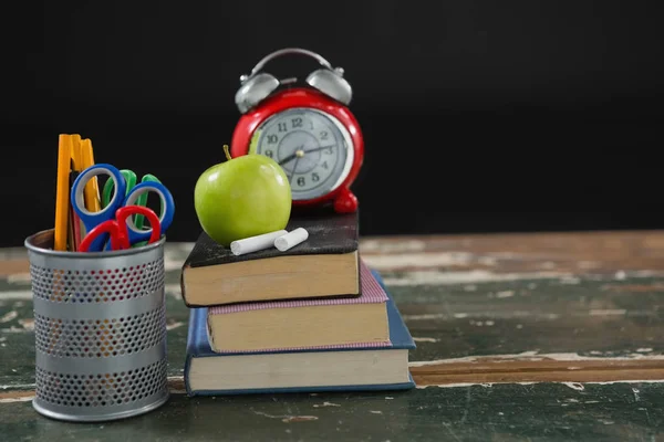 Réveil, pomme et craie sur pile de livres — Photo