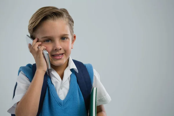 Cep telefonu üzerinde konuşurken mutlu okul çocuğu portresi — Stok fotoğraf