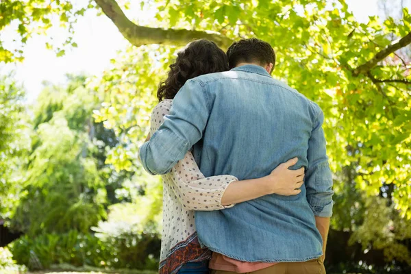 Paar omhelzen elkaar in de tuin op een zonnige dag — Stockfoto