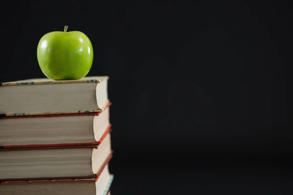 Zelené jablko na stoh knih — Stock fotografie