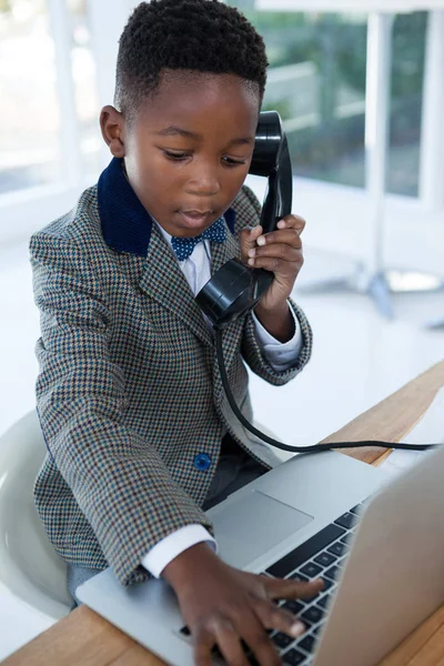 Homme d'affaires tapant sur ordinateur portable tout en utilisant le téléphone — Photo