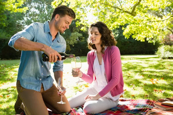 Homme versant du vin dans les femmes verre dans le parc — Photo