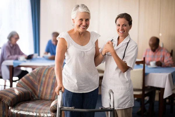 Mujer mayor con médico femenino por caminante — Foto de Stock