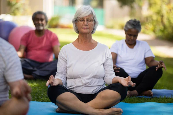 Mujer mayor meditando con los ojos cerrados — Foto de Stock