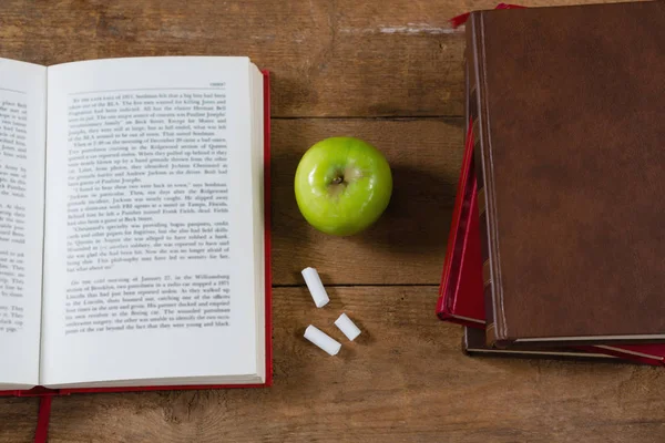 Geopend boek, groene appel en krijt — Stockfoto