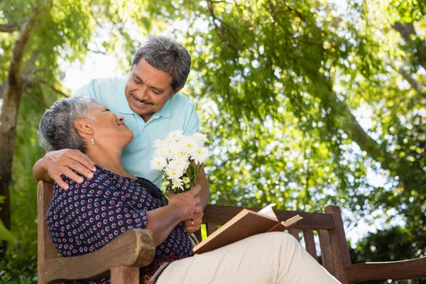 Hombre mayor dando flores a la mujer — Foto de Stock
