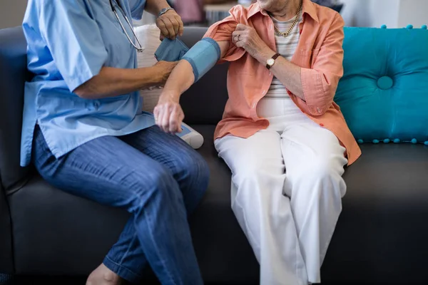 Médecin vérifiant la pression artérielle des femmes âgées — Photo