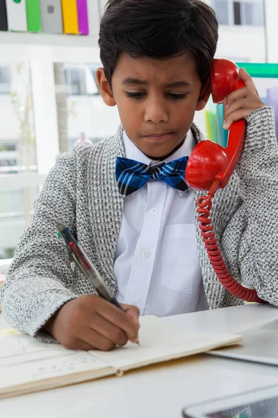 Jongen imiteren als zakenman op boek schrijven — Stockfoto