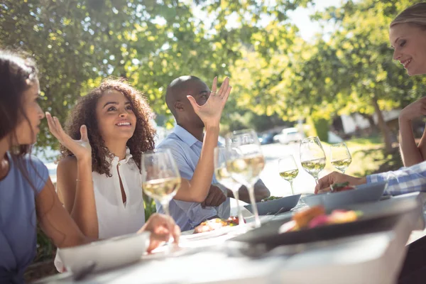 Glückliche Freunde, die beim Essen miteinander interagieren — Stockfoto