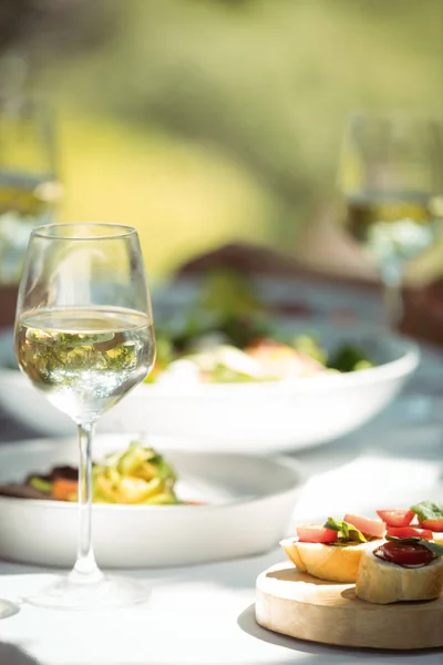 Comida y copa de vino en la mesa de comedor — Foto de Stock