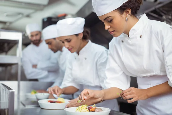 Chef mujer guarnición de alimentos en la cocina — Foto de Stock