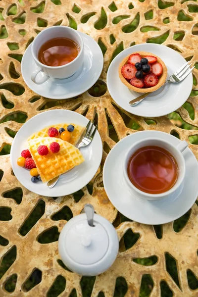 Filiżanka herbaty z deser na stole — Zdjęcie stockowe
