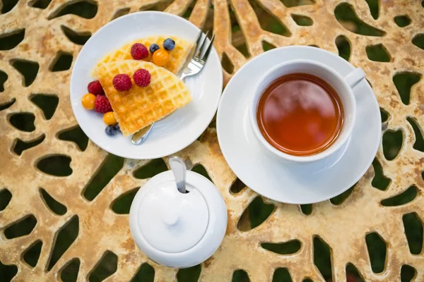 Xícara de chá com sobremesa na mesa — Fotografia de Stock