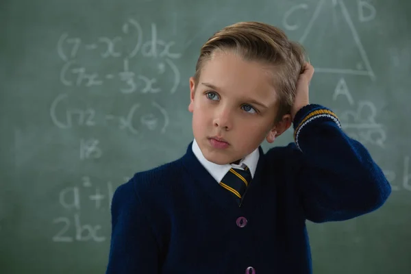 Schooljongen permanent tegen schoolbord — Stockfoto