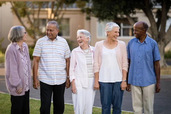 Seniors standing while looking at each other — Stock Photo, Image
